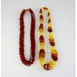 Two amber disk necklaces, one in red, measuring approximately 54cm in length, and one in multi