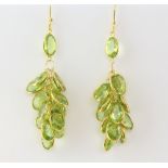 Oval cut peridot tassel earrings, mounted in yellow metal stamped testing as 14 ct, with hook