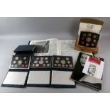 Eleven proof UK coin sets in presentation cases and two royal memorabilia books.
