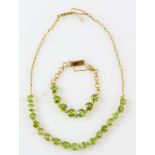 Peridot necklace, seventeen round cut peridot, claw set in yellow metal testing as 18 ct,