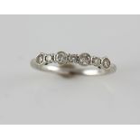 Diamond set ring set with round and oval cut diamonds in rub over and claw settings, mounted in 18
