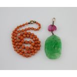 Carved jade and pink tourmaline pendant, length, 7 cm and a coral bead necklace with gold bolt ring,