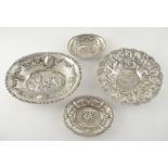 Four German silver bonbon dishes, each with embossed central panel depicting putti or rural