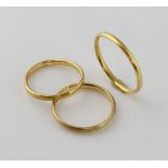 Three gold wedding bands, one hallmarked London 1952, size K, with matching wedding band, ring
