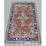 Persian type red ground carpet with a main blue border the centre with repeating foliate forms,