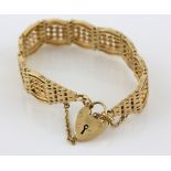 Gold hinged gate bracelet, with plain and twisted links, heart padlock clasp and safety chain,