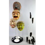 CORRECTION TO DESCRIPTIONFour Balinese / Indonesian masks on a Perspex display stand and another