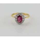 Ruby and diamond cluster ring, oval cut ruby, estimated weight 1.64 carats, set within a border of