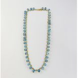 Blue topaz necklace, set with forty-eight oval cut blue topaz, each connected by circular links,