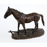 Apul Edouard D, a bronze figure of a horse beside a low fence on a naturalistic cast base, 23cm high