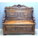 Early 20th century carved oak settle with box seat. 129cm wide, 50cm deep, 115cm high