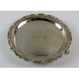 George V silver salver with pie crust rim on three shaped feet, maker's mark rubbed, London, 1930,