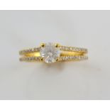 Diamond ring, with brilliant cut stone on a double diamond set band, mounted in yellow gold, central