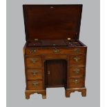 19th Century mahogany kneehole desk with hinged top revealing a fitted interior and six drawers,