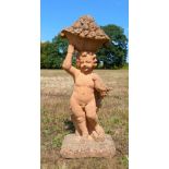 Composite stone garden statue in the from of a cherub holding a basket of fruit, 105cm high