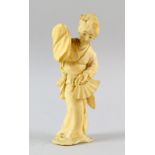 Early 20th century Japanese carved ivory figure of a woman in a robe holding a fan, 15cm high,.