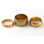 Three gold rings, vintage wide ring engraved with star pattern, hallmarked London 1967, size P, a