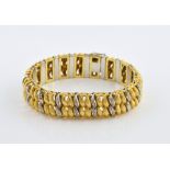 Vintage gold bracelet of textured and diamond set scroll links, measuring 18.5cm in length, with
