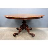 Victorian rosewood breakfast table of serpentine form, on turned column and scrolling quatrefoil