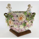 19th Century Dresden floral encrusted centre piece finials in the form of two cherubs 35 cm wide .