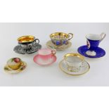 A group of six cups and saucers, to include two Worcester cups and saucers, a silver and gilt KPM