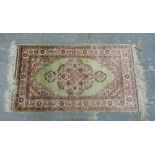 Turkish silk rug foliate design, predominately in pinks and greens108cm x 0.62cm