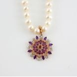 A cultured pearl necklace with attached pendant set with amethyst diamond and central synthetic ruby