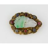 Jade, sapphire and ruby brooch, central jadeite jade carved in floral motif, surrounded by four