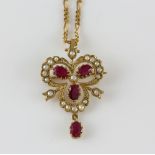Ruby and seed pearl pendant brooch, four oval cut rubies set in clover motif set with a border of