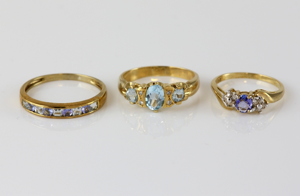 Three gem set rings, blue topaz and diamond ring, with a central oval cut and two round cut blue