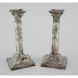 Pair of modern silver Corinthian column candlesticks with bow and swag decoration, on square