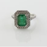 Emerald and diamond set white gold ring, the step cut emerald within a double border of diamonds,