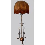 An Arts & crafts wrought iron and brass adjustable standard lamp, on three leaf form feet, with