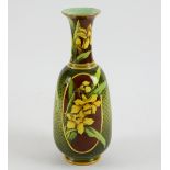 An unusual Doulton faience vase, painted with daffodils on a reserve of brown ovals and pattern of