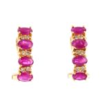 Apair of ruby and diamond earrings. Each designed as a series of four oval-shape rubies, with