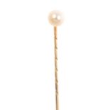 An early 20th century cultured pearl stickpin. The cultured pearl, atop a grooved stick pin.