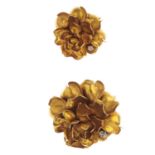 Two mid 20th century gold diamond brooches. Each designed as a flower, suspending an old-cut diamond