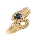 An 18ct gold sapphire and diamond crossover ring. The pear-shape sapphire, with brilliant-cut