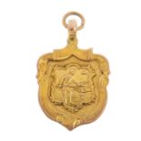 An early 20th century 9ct gold medallion fob. Of shield design, depicting a game of billiards.