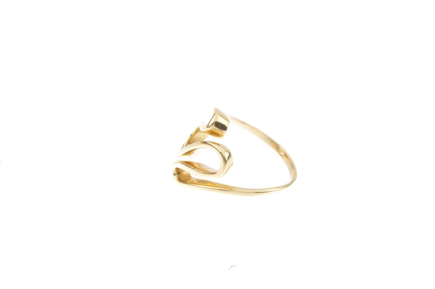 A dress ring. The front designed as a series of scrolling loops, with plain band. Ring size O. - Image 2 of 3