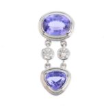 A tanzanite and diamond pendant. The oval-shape tanzanite collet, with brilliant-cut diamond