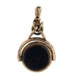 An early 20th century gold gem-set fob. Designed as a circular bloodstone and banded onyx panel,