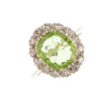 A peridot and diamond cluster ring. The oval-shape peridot, with single-cut diamond surround.