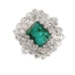 An emerald and diamond cluster ring. The rectangular-shape emerald, within an old-cut diamond double