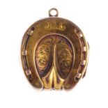 An early 20th century locket. The horseshoe locket, with engraved foliate motif and grooved