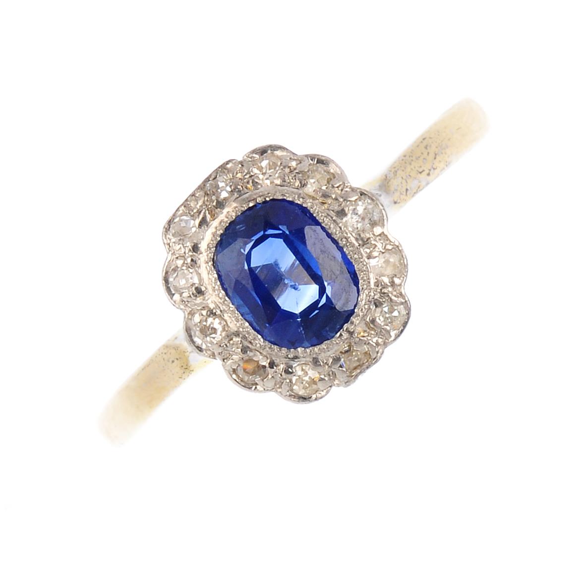 A sapphire and diamond cluster ring. The oval-shape sapphire, with single-cut diamond scalloped