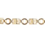 A 9ct gold bracelet. Designed as a series of textured pyramid-shape fancy links, with hoop spacers