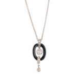 A diamond and onyx pendant. The brilliant-cut diamond collet, within an onyx halo surround, with