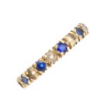 A paste eternity ring. Designed as an alternating circular-shape blue and white paste line. Ring