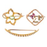 Three gem-set brooches. To include an early 20th century gold garnet and seed pearl floral brooch, a